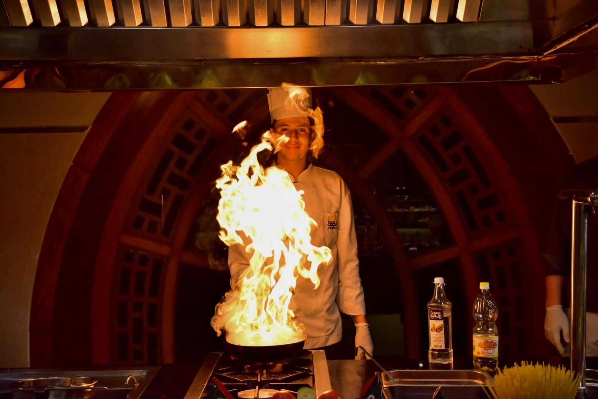 The Grand Hotel Sharm El Sheikh 외부 사진 A chef cooking with a flaming wok